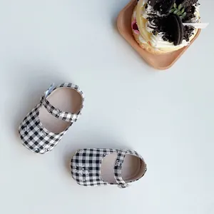 Detalle de zapatos Mary Jane para bebé con cuadros blancos y negros y dibujos de conejos