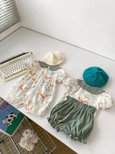 Flat lay of baby summer set with fox forest print rompers and bubble sleeves outfits