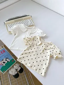 Detail of baby tops featuring Peter Pan collar with ruffles and polka dot bubble sleeves
