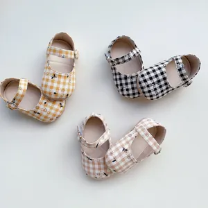 Vista superior de zapatos de bebé de cuadros vichy con bordados florales en varios colores