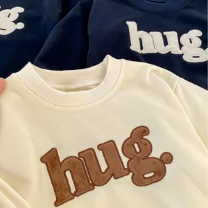 Minimalist long-sleeve baby bodysuit with 3D hug embroidery and ribbed crew neck design
