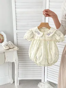 Détail d'une barboteuse fleurie pour bébé avec col brodé et manches bouffantes