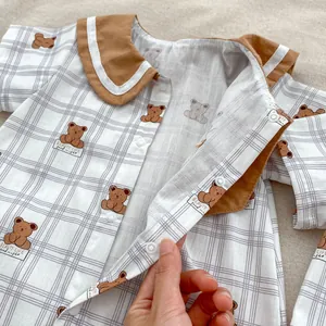 Detail of baby summer romper featuring cute bear prints and brown Peter Pan collar