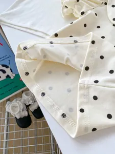 Close-up of polka dot baby cotton shirt sleeve with fine stitching and soft texture