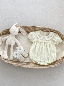 Body bébé à fleurs avec col brodé et chaussures à dentelle dans un panier tressé