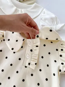Detail of baby cotton blouse showing rounded doll collar and soft polka dot fabric texture