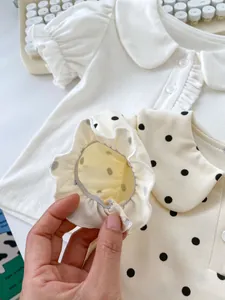 Detailed close-up of ruffle elastic trim on a baby girl polka dot cotton outfit set
