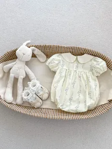 Détail d'un ensemble barboteuse fleurie et chaussures en dentelle dans un panier