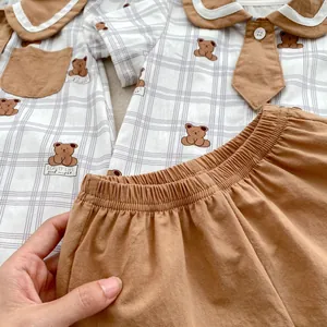 Short-sleeve baby boy romper with bear print and plaid shirt design in brown
