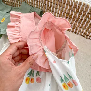 Détail d'une barboteuse pour bébé fille avec bords à volants et broderie tulipe