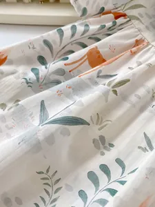 Macro view of baby cotton fabric featuring giraffe animal prints and pleated waist details