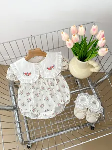 Baby floral romper with embroidered collar and matching lace bow walking shoes in a cart