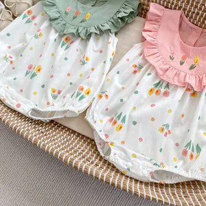Détail de bodies bébé avec broderie tulipe et col à volants sur tissu à fleurs coton