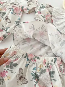 Detailed view of floral baby girl outfit with lace trim and elastic waist texture