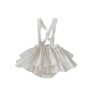 Infant cream white ruffled suspender romper with layered princess skirt and crossed straps