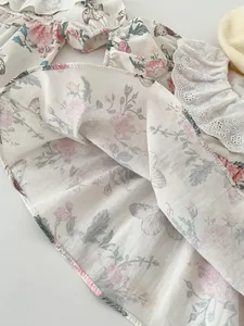 Close-up of floral print cotton baby bodysuit with delicate white lace embroidery details