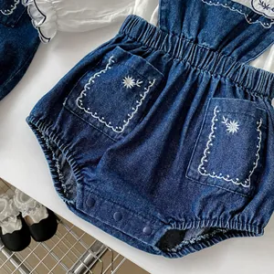 Barbeute bébé en jean bleu avec broderies fleurs blanches et boutons pressions