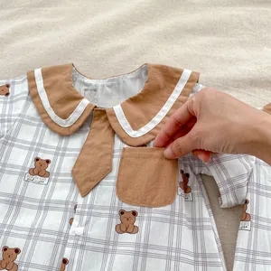 Detail of baby bear print romper featuring navy collar, bowtie and front pocket