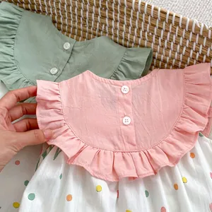 Détail d'une barboteuse d'été pour bébé avec col à volants rose et imprimés à pois