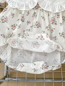 Detail of baby floral bodysuit with ruffle collar and snap closures on breathable fabric