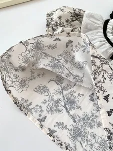 Close-up of floral ink print cotton linen fabric with black velvet piping detail