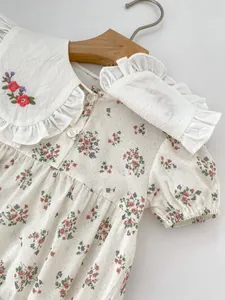 Detail of baby floral bodysuit with lace collar and delicate flower embroidery