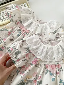 Detail of floral baby bodysuit featuring lace collar, puff sleeves and embroidery