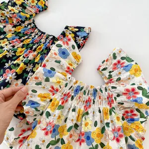 Detail of floral baby summer tops featuring elastic pleated necklines and vibrant prints
