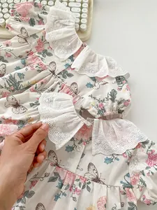 Close-up of floral print baby romper with white lace collar and delicate butterfly patterns