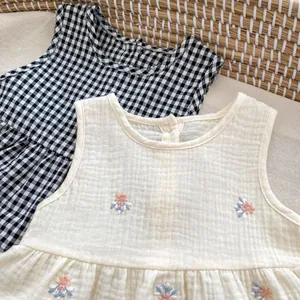 Detail of baby girl summer sets showing plaid cotton and floral embroidered muslin fabric