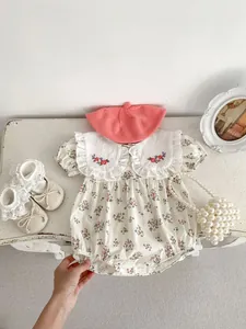 Flat lay of baby floral romper with embroidered ruffle collar and pink knit beret set