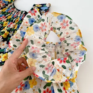 Detailed view of floral pattern and ruffled neckline on cotton baby summer tank top