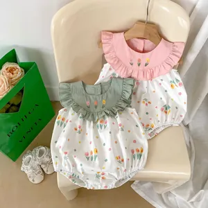 Détail du col à volants brodé de fleurs sur des barboteuses d'été en coton pour bébé