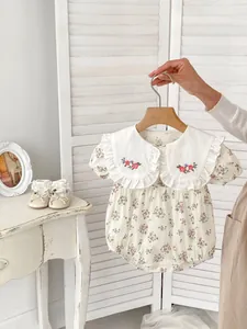 Close-up of baby floral romper featuring a large Peter Pan collar with flower embroidery