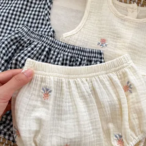 Close-up of soft cotton muslin fabric with floral embroidery and plaid pattern