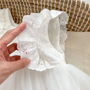 Detalle de vestido blanco para bebé con bordado floral y falda de tul de varias capas