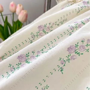 Barboteuse blanche pour bébé avec imprimé floral violet et col claudine brodé élégant