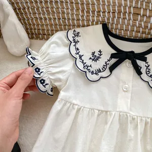 Infant girl embroidered short sleeve romper with navy floral collar and bow detail