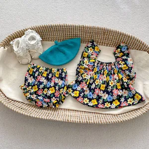 Flat lay of baby girl floral top, matching bloomers, blue beret, and lace shoes in a cradle