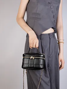 Quilted black leather box bag with gold chain strap and top handle for women