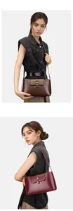 Details minimalistischer Schultertaschen aus Leder in Dunkelbraun und Weinrot mit Schnalle