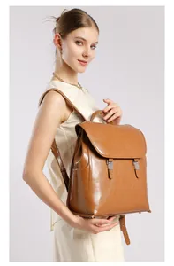 Zaino marrone in pelle cerata indossato da una modella con fibbie metalliche vintage