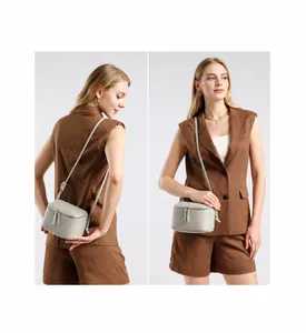 Vue détaillée du petit sac bandoulière cylindrique en cuir gris clair avec zip