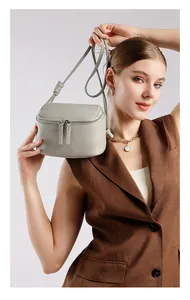 Détail du sac bandoulière gris en cuir grainé avec sangle nouée et double fermeture éclair