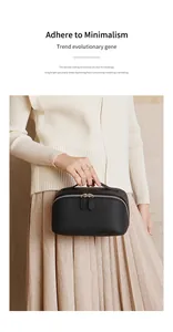 Detail of black pebbled leather cosmetic bag with double zippers and silver metal pullers
