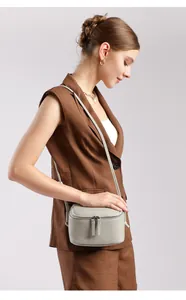 Détail de la texture en cuir gris et double fermeture éclair du sac bandoulière