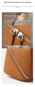 Close-up of durable silver metal dual zippers on premium brown lychee grain leather pouch