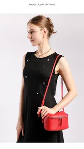 Détail du sac bandoulière en cuir rouge grainé avec fermeture éclair et doubles glands