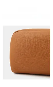Detailed close-up of neat stitching and lychee grain texture on leather cosmetic bag base