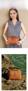 Close-up of handmade brown leather travel cosmetic bag with silver zippers and top handle